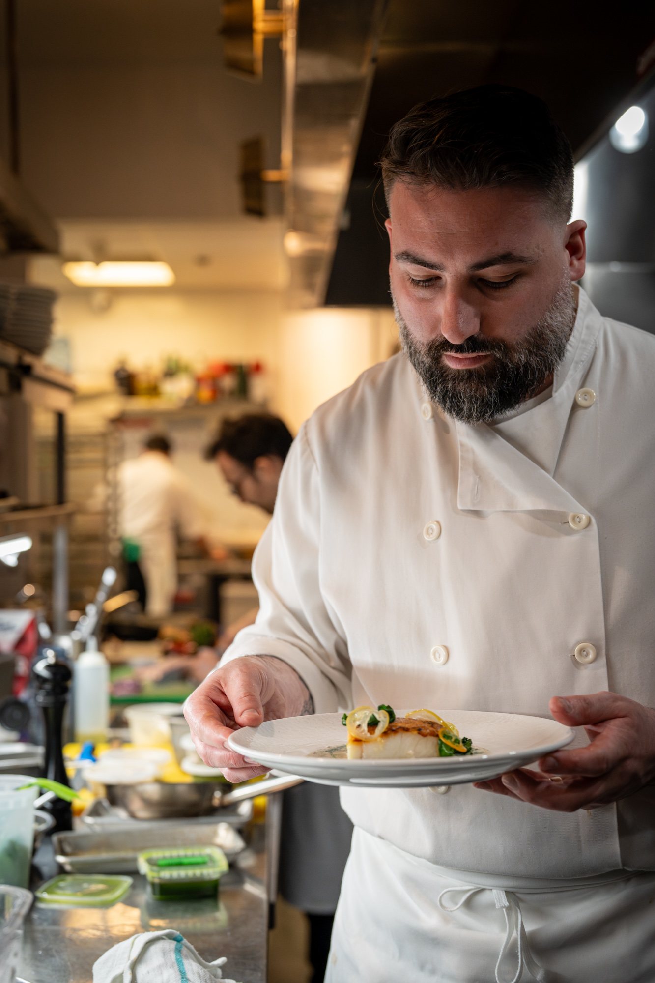 Chef Michael Angeloni presenting a dish in Restaurant Lucie's kitchen