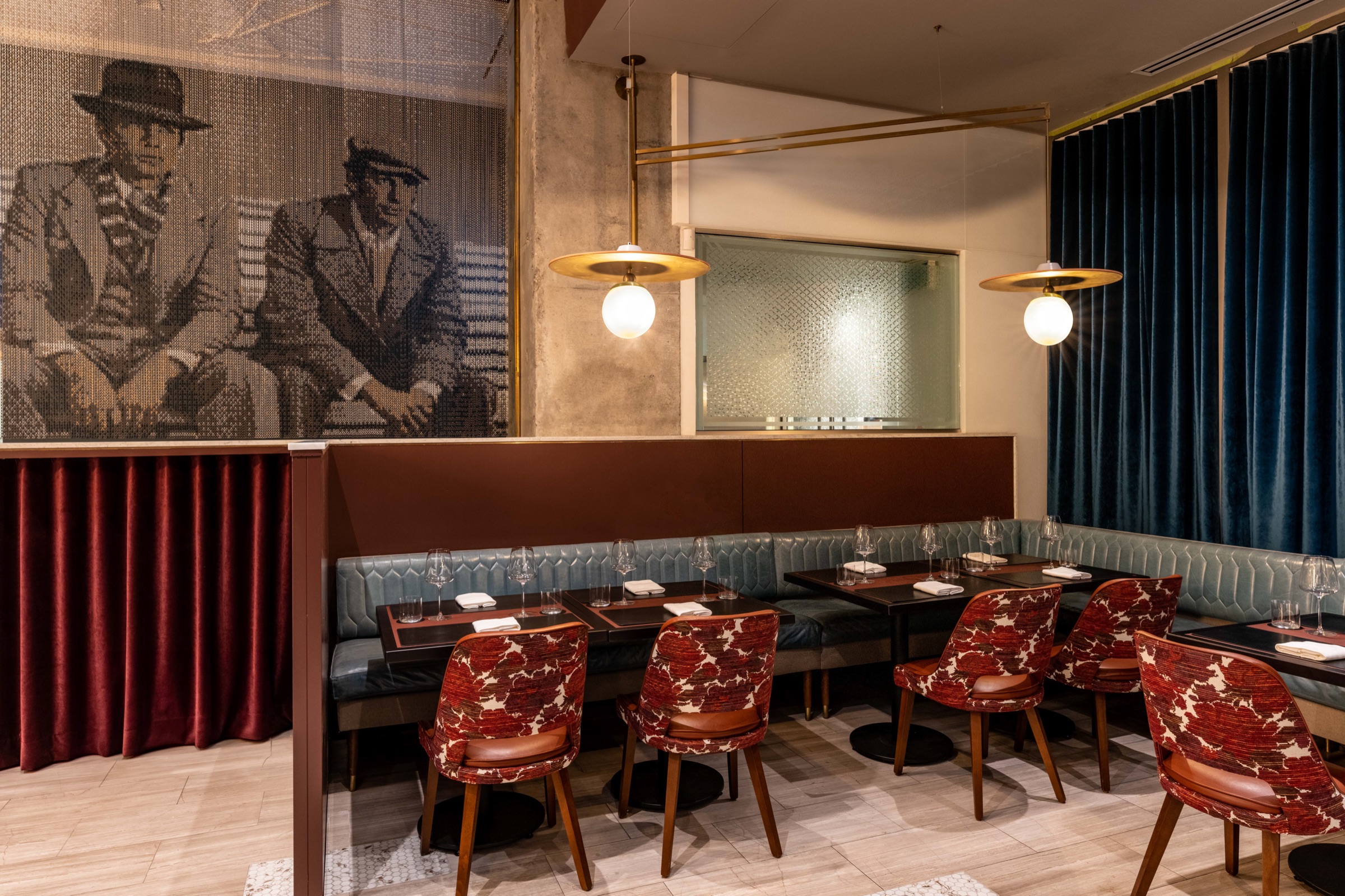 The main dining room at Restaurant Lucie — teal banquettes, warm pendant lighting